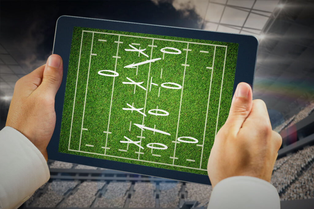 Halı sahada çevresini kontrol ederek hızlı karar vermeye çalışan bir futbolcu.