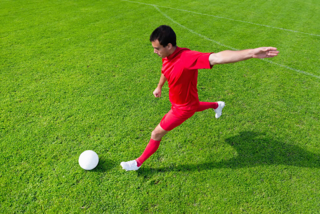 Halı sahada dar alanda top saklama ve kontrol tekniği uygulayan bir futbolcu.